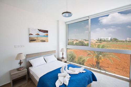 ein Schlafzimmer mit einem Bett und einem großen Fenster in der Unterkunft Villa Manta Platina - Brand New Luxury 3 Bedroom Protaras Villa in Protaras