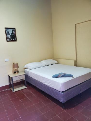 a bedroom with two beds and a side table at El Sol Hostel in León