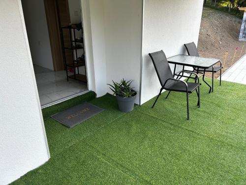 a patio with a table and chairs on the grass at Vila Fina in Laktaši