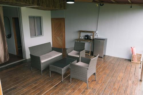 a room with chairs and a couch and a table at The Journey Hostel in Los Naranjos