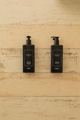 three bottles of soap sitting on a wall at Boomerang Village in Torre Colimena