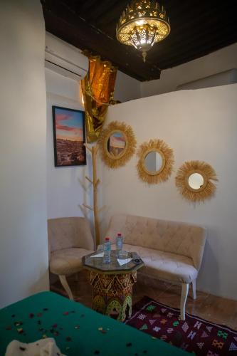 a living room with a couch and a table and mirrors at Riad Shauala Fez in Fès