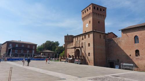 a large brick building with a clock tower at Pit Stop - Bilocale inTerra di Motori, Cibo e Arte in Formigine