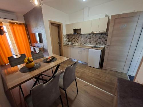 a kitchen with a table and chairs in a room at Apartman Jasmin in Bukorovac