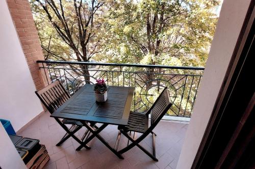 a wooden table with two chairs on a balcony at Pit Stop - Bilocale inTerra di Motori, Cibo e Arte in Formigine