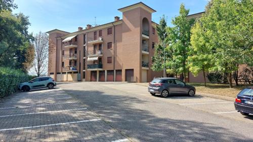 two cars parked in a parking lot in front of a building at Pit Stop - Bilocale inTerra di Motori, Cibo e Arte in Formigine