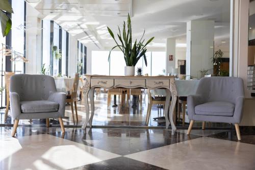 a dining room with a table with chairs and a plant on it at Hotel Flamingo in L'Ampolla