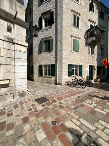 a building with two bikes parked in front of it at Balcony with Old Town view in Kotor