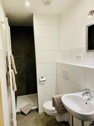 a white bathroom with a toilet and a sink at Hotel Altstadt Wöllbacher Tor in Wetzlar