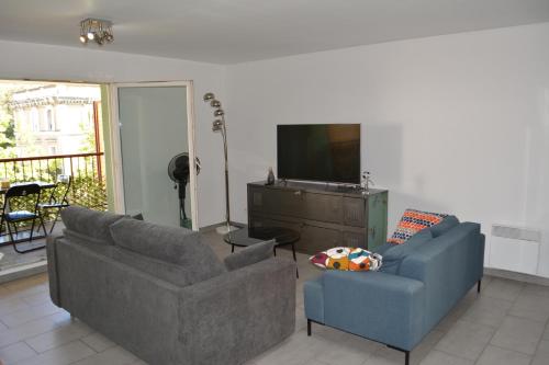 un salon avec deux canapés et une télévision à écran plat dans l'établissement JOLI T3 MARSEILLE au calme, à Marseille