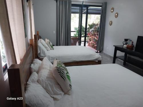 a bedroom with two beds and a balcony at Casa Honey in Bajo Boquete