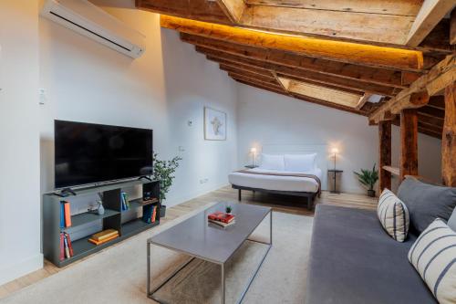 a living room with a couch and a tv at Fomento by Wynwood House in Madrid