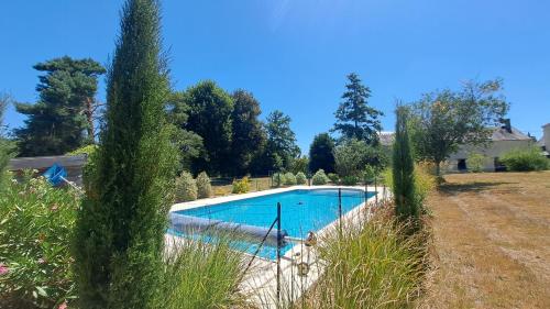 - une piscine dans une cour avec de l'herbe haute dans l'établissement Belle demeure avec piscine à Bourgueuil 5 ch/10 p, à Bourgueil
