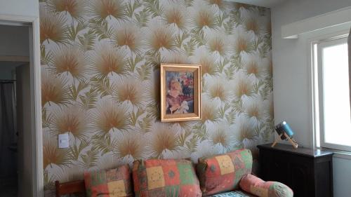 a living room with a couch and a wall at Apartamento Edificio Niza Península Se Reserva con SEÑA in Punta del Este