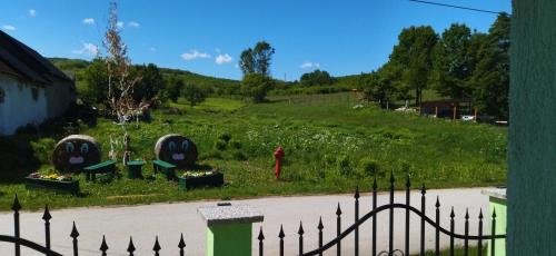 a yard with a fence and flowers in a field at KOÓS VENDÉGHÁZ in Uppony
