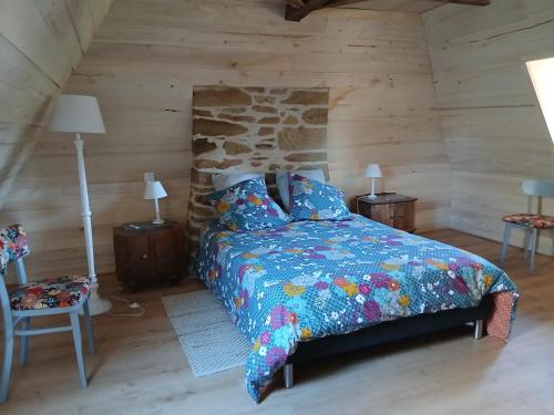 une chambre avec un lit dans une cabane en rondins dans l'établissement Petite maison avec piscine, à Vezels-Roussy