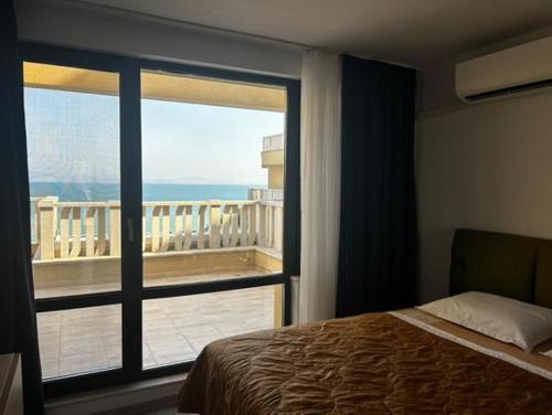 a bedroom with a bed and a view of a balcony at Sea View Luxury Apartment in Bŭnzareto