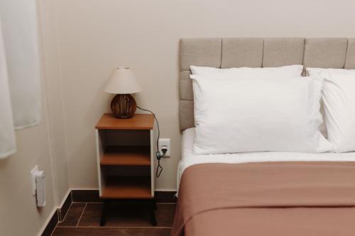 a bedroom with a bed and a nightstand with a lamp at Casa da Coruja in Rio de Janeiro