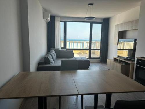 a living room with a couch and a table with a view at Sea View Luxury Apartment in Bŭnzareto