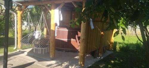 a wooden structure with a playground with a swing at KOÓS VENDÉGHÁZ in Uppony