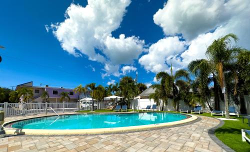 a swimming pool in a yard with palm trees at Stylish 1b1b Unit With Kitchen And Pool in Clearwater