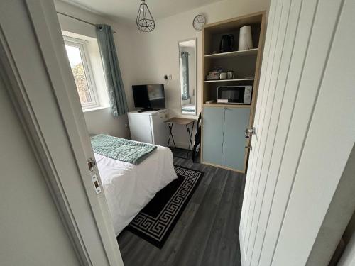 1 dormitorio con 1 cama y escritorio con microondas en Private Room - Ensuite Bathroom - Free Parking, en Birmingham
