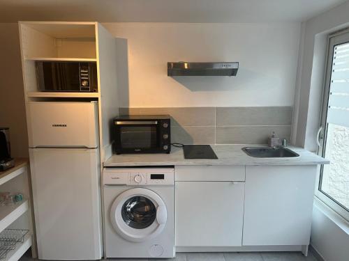 a kitchen with a washing machine and a microwave at Studio Argenteuil in Argenteuil