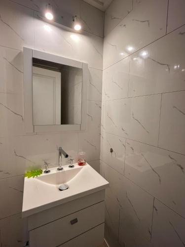 a white bathroom with a sink and a mirror at Tandil Centro vistas in Tandil