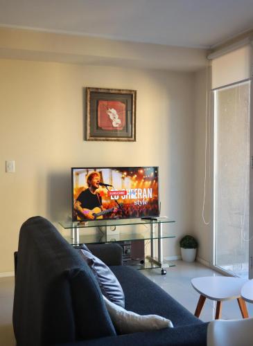 a living room with a couch and a flat screen tv at Tandil Centro vistas in Tandil