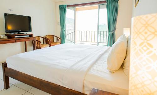 a bedroom with a large bed and a television at Celyn Resort Kinabalu in Kampong Kundassan