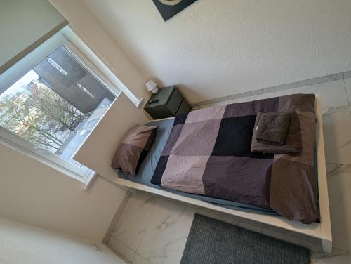 a bedroom with a bed in a room with a window at Nord Apartment 8 Moderne Ferienwohnung mit Regendusche & Fußbodenheizung in Bremerhaven