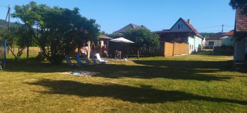 a group of people sitting on chairs in a yard at KOÓS VENDÉGHÁZ in Uppony