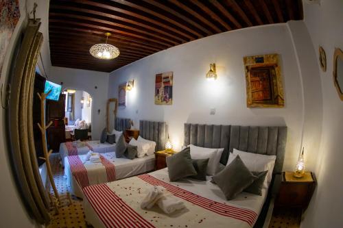 a hotel room with two beds and a mirror at Riad Shauala Fez in Fès