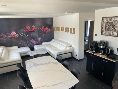 una sala de estar con un sofá y una mesa en La Maison des Lacs et des Parcs, en Amance