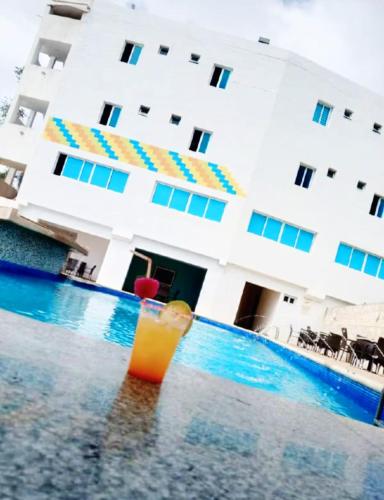 a drink in the pool in front of a building at Hotel Aventura suite in Boca de Aroa