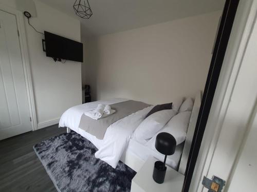 a bedroom with a bed with white sheets and pillows at Private Room with Ensuite Bathroom & Free Parking in Birmingham