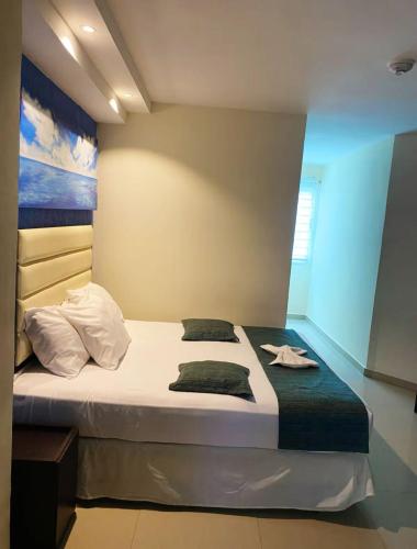a bedroom with a large bed with white sheets at Hotel Aventura suite in Boca de Aroa