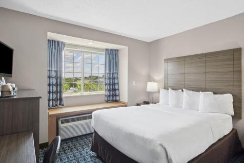 a hotel room with a large bed and a window at Sonesta Essential Hotel Blue Springs in Blue Springs