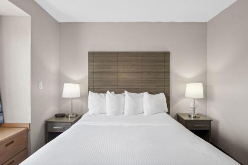 a hotel room with a large bed with two lamps at Sonesta Essential Hotel Blue Springs in Blue Springs