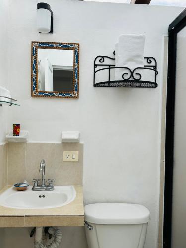 a bathroom with a toilet and a sink and a mirror at The Quetzal in Cancún