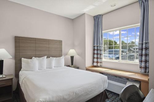 a hotel room with a large bed and a window at Sonesta Essential Hotel Blue Springs in Blue Springs
