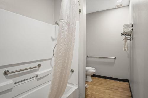 a bathroom with a toilet and a shower curtain at Sonesta Essential Hotel Blue Springs in Blue Springs