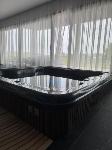 a bath tub in a room with a window at Harmony Resort & Spa in Padumble