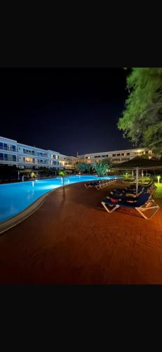 a person standing next to a swimming pool at night at 7 Degrees South in Lagos