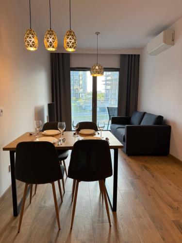 a dining room with a table and chairs and a couch at Apartament KTW3 in Katowice