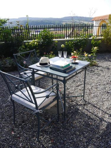 a table and a chair with a book and glasses at Chateau de Marnand in Granges-près-Marnand
