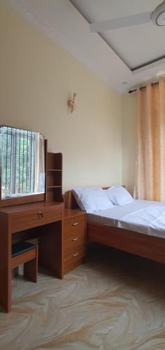 a bedroom with two beds and a desk and a television at Hopeland Villas in Msaranga