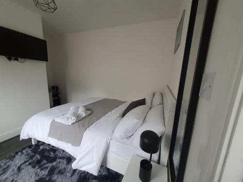 a bedroom with a bed with white sheets and pillows at Private Room with Ensuite Bathroom & Free Parking in Birmingham