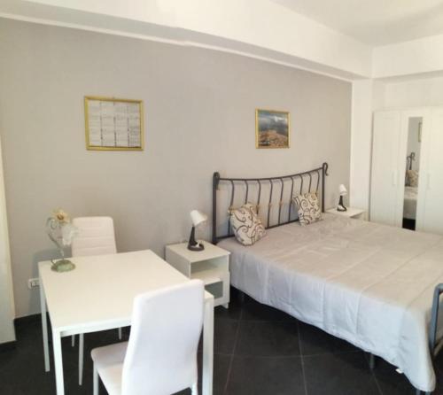 a bedroom with a bed and a white table and chairs at Avignone 96 - Moderno bilocale zona centro in Messina