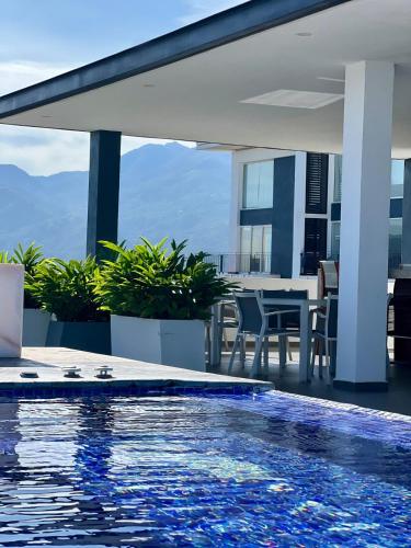 a swimming pool on the roof of a house with a table at Chic 1BR 1BA Zoho Skies condo with rooftop pool stunning views in Puerto Vallarta